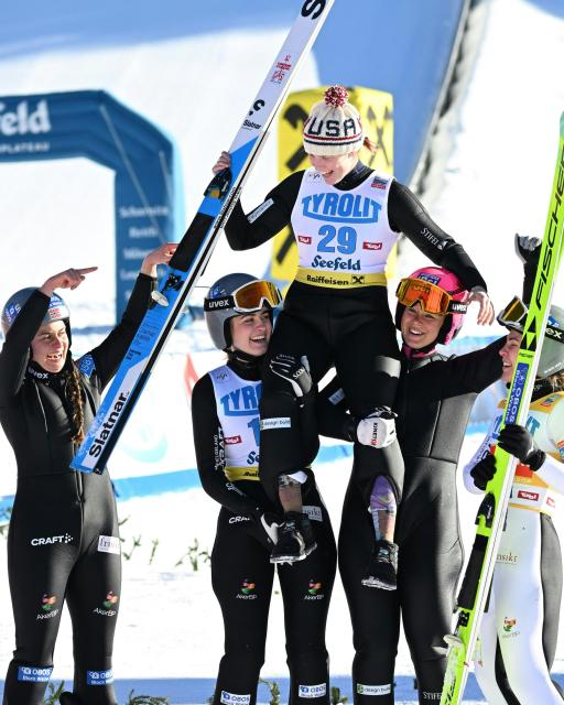 US's Alexa Brabec (C, top) is celebrated after winning the women's Normal Hill Mass Start event at the FIS Ski Nordic Combined World Cup, on January 30, 2026 in Seefeld, Austria. (Photo by BARBARA GINDL / APA / AFP) / Austria OUT