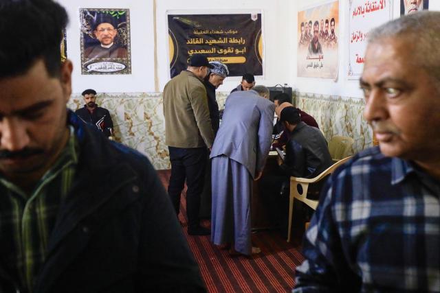 Men registers to join the so-called “Martyrs’ Brigades” under the umbrella of Iraq's pro-Iran armed group Harakat al-Nujaba, which called on Iraqis to volunteer to fight alongside Iran in the event of a full-scale war with the United States and Israel, in Hillah on January 30, 2026. Iran threatened on January 30, to instantly strike US bases and aircraft carriers in response to any attack, after the US president warned time was running out for Tehran and the EU blacklisted its Revolutionary Guards as a terror group. (Photo by Karrar Jabbar / AFP)