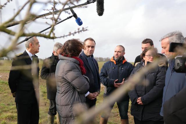 France's Prime Minister Sebastien Lecornu (C), Prefect of the Eure-et-Loir department Herve Jonathan (L) and France's Agriculture Minister Annie Genevard (3rd L) tour an almond orchard during a visit to promote local and diversified agriculture, in Baigneaux, central France, on January 30, 2026. The prime minister is visiting the Eure-et-Loire department to launch the "contracts for the future" demanded by the Jeunes Agriculteurs (Young Farmers) union, aimed at diversifying production, notably in the face of climate change, and to present the Governments efforts to increase the share of local food in public procurement. (Photo by Thomas SAMSON / AFP)