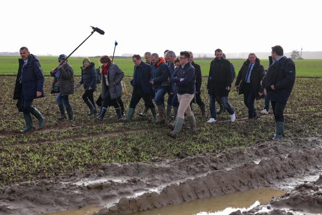 France's Prime Minister Sebastien Lecornu (C) tours an almond orchard during a visit to promote local and diversified agriculture, in Baigneaux, central France, on January 30, 2026. The prime minister is visiting the Eure-et-Loire department to launch the "contracts for the future" demanded by the Jeunes Agriculteurs (Young Farmers) union, aimed at diversifying production, notably in the face of climate change, and to present the Governments efforts to increase the share of local food in public procurement. (Photo by Thomas SAMSON / AFP)