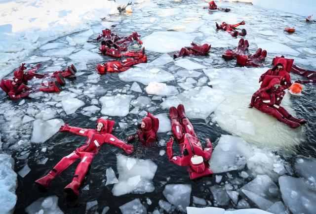 Participants wearing isothermal wetsuits float among ice floes in a hole on the frozen Moskva river as they enjoy ice floating - the growing relaxation trend, in Moscow on January 30, 2026. (Photo by Alexander NEMENOV / AFP)