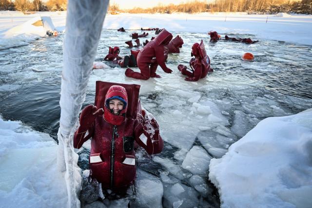 Participants wearing isothermal wetsuits float among ice floes in a hole on the frozen Moskva river as they enjoy ice floating - the growing relaxation trend, in Moscow on January 30, 2026. (Photo by Alexander NEMENOV / AFP)