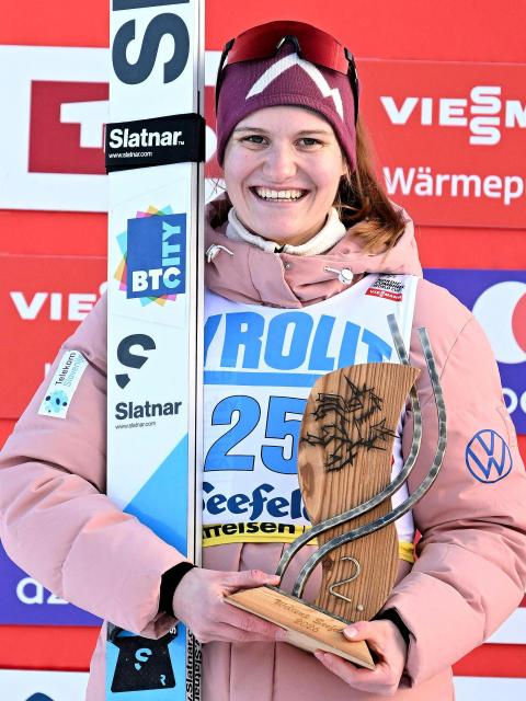 Second placed Slovenia's Ema Volavsek celebrate on the podium with the trophy after winning the women's Normal Hill Mass Start event at the FIS Ski Nordic Combined World Cup, on January 30, 2026 in Seefeld, Austria. (Photo by BARBARA GINDL / APA / AFP) / Austria OUT