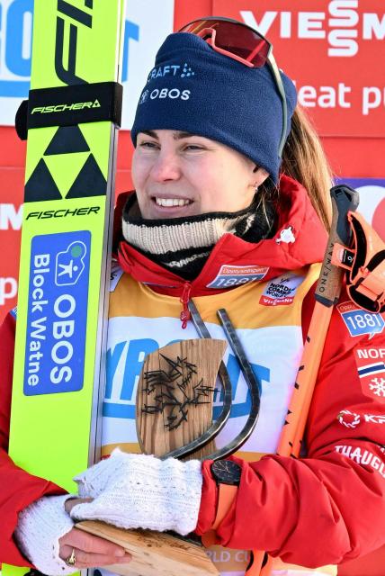 Third placed Norway's Ida Marie Hagen celebrates with the trophy on the podium after winning the women's Normal Hill Mass Start event at the FIS Ski Nordic Combined World Cup, on January 30, 2026 in Seefeld, Austria. (Photo by BARBARA GINDL / APA / AFP) / Austria OUT