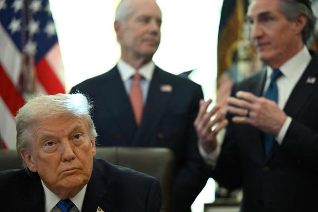 US President Donald Trump looks on as Interior Secretary Doug Burgum (R) speaks before signing executive orders in the Oval Office in the White House in Washington, DC, on January 30, 2026. (Photo by Annabelle GORDON / AFP)