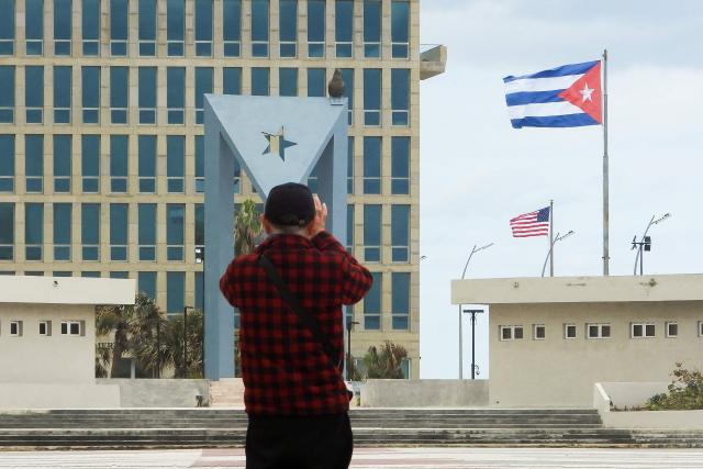 A tourist takes pictures of the US Embassy with the US flag and the Cuban flag in the background in Havana on January 30, 2026. Cuban President Miguel Diaz-Canel on January 30, 2026, denounced US President Donald Trump’s attempt to “asphyxiate” the communist island’s economy under a “false pretext.” (Photo by ADALBERTO ROQUE / AFP)