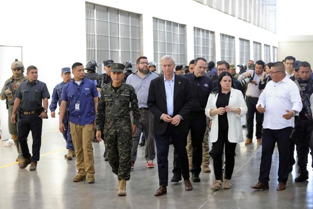 Chile's president-elect Jose Antonio Kast (C) walks next to El Salvador's Defense Minister Rene Merino Monroy (C-L) during a visit to the Counter-Terrorism Confinement Centre (CECOT) mega-prison, where hundreds of MS-13 and 18th Street gang members are being held, in Tecoluca, El Salvador, on January 29, 2026. The CECOT, the largest prison in Latin America and emblem of the war against gangs of the government of President Nayib Bukele, celebrates two years since it was inaugurated on February 1. (Photo by Oscar RIVERA / AFP)