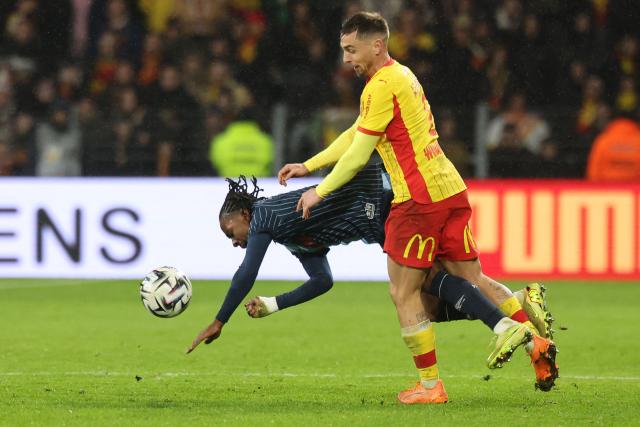 Le Havre's Swiss forward #10 Felix Mambimbi (L) falls to the ground under a challenge from Lens' French defender #02 Ruben Aguilar (R) during the French L1 football match between RC Lens and Le Havre AC at the Stade Bollaert-Delelis in Lens, northern France, on January 30, 2026. (Photo by Francois LO PRESTI / AFP)