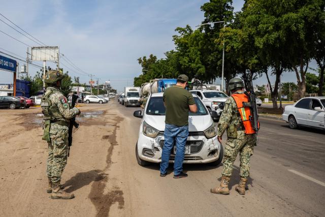 Mexican soldiers carry out a security checkpoint on a street in Culiacan, Sinaloa state, Mexico on January 30, 2026. Security in the northwestern Mexican state of Sinaloa was reinforced with 1,600 military personnel on January 29, 2026, after two local deputies were shot and ten workers from a Canadian mine were kidnapped. The troops were deployed just as President Claudia Sheinbaum was on the phone with her US counterpart, Donald Trump, to discuss security and trade. (Photo by Jesus VERDUGO / AFP)