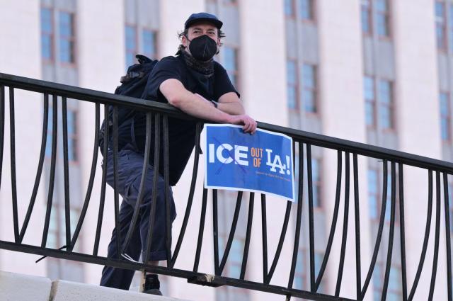 A man holds a sign during a "National Shutdown" protest against US Immigration and Customs Enforcement (ICE) in Los Angeles on January 30, 2026. Donald Trump's border chief said January 29, 2026 that some federal agents could be withdrawn from Minneapolis, the northern US city that has become the flashpoint for the president's immigration crackdown. The Trump administration, facing a public backlash over the shooting deaths of two Americans by federal agents in Minneapolis, also eased immigration operations in the northeastern state of Maine. (Photo by Frederic J. Brown / AFP)