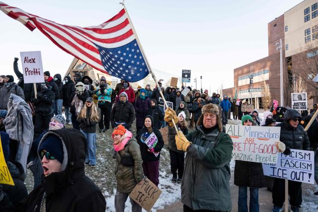 A man waves a US flag during a "National Shutdown" protest against US Immigration and Customs Enforcement (ICE) in Minneapolis, Minnesota, on January 30, 2026. Donald Trump's border chief said January 29, 2026 that some federal agents could be withdrawn from Minneapolis, the northern US city that has become the flashpoint for the president's immigration crackdown. The Trump administration, facing a public backlash over the shooting deaths of two Americans by federal agents in Minneapolis, also eased immigration operations in the northeastern state of Maine. (Photo by ROBERTO SCHMIDT / AFP)