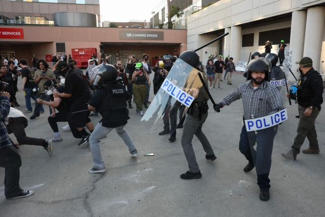 Protestors clash with police during a "National Shutdown" protest against U.S. Immigration and Customs Enforcement in Los Angeles on January 30, 2026. Donald Trump's border chief said January 29, 2026 that some federal agents could be withdrawn from Minneapolis, the northern US city that has become the flashpoint for the president's immigration crackdown. The Trump administration, facing a public backlash over the shooting deaths of two Americans by federal agents in Minneapolis, also eased immigration operations in the northeastern state of Maine. (Photo by Patrick T. Fallon / AFP)