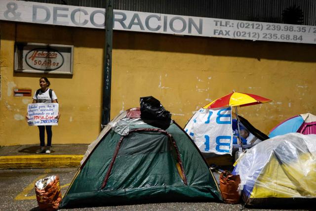 A woman shows a sign during a demonstration to demand the release of political prisoners outside the Zone 7 prison of the Bolivarian National Police (PNB) in Caracas on January 30, 2026. Venezelan interim President Delcy Rodriguez announced a "general amnesty" law in Venezuela on January 30, 2026, just days before marking one month since she took power following the overthrow of Nicolas Maduro in a US military incursion. (Photo by Pedro MATTEY / AFP)