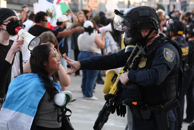 A law enforcement agent places his hand in front of a protestor's face during a "National Shutdown" protest against U.S. Immigration and Customs Enforcement in Los Angeles on January 30, 2026. Donald Trump's border chief said January 29, 2026 that some federal agents could be withdrawn from Minneapolis, the northern US city that has become the flashpoint for the president's immigration crackdown. The Trump administration, facing a public backlash over the shooting deaths of two Americans by federal agents in Minneapolis, also eased immigration operations in the northeastern state of Maine. (Photo by Patrick T. Fallon / AFP)