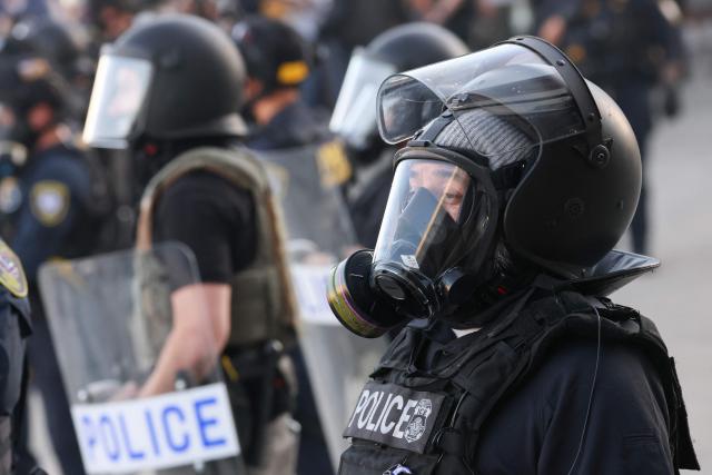 A law enforcement agent stands by during a "National Shutdown" protest against U.S. Immigration and Customs Enforcement in Los Angeles on January 30, 2026. Donald Trump's border chief said January 29, 2026 that some federal agents could be withdrawn from Minneapolis, the northern US city that has become the flashpoint for the president's immigration crackdown. The Trump administration, facing a public backlash over the shooting deaths of two Americans by federal agents in Minneapolis, also eased immigration operations in the northeastern state of Maine. (Photo by Patrick T. Fallon / AFP)