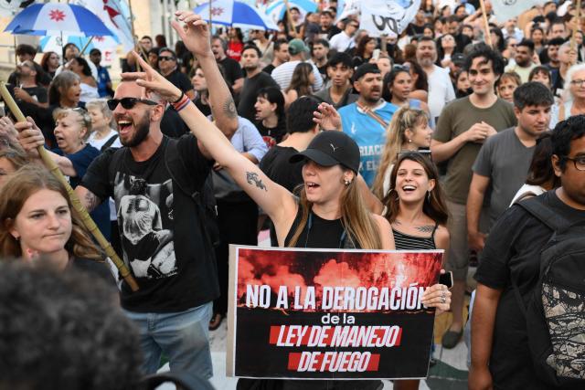 People take part in a protest to demand more help to combat wildfires in Patagonia from Argentina's President Javier Milei government in Buenos Aires on January 30, 2026. Argentina's government on declared an emergency in Patagonia on January 29, 2026, where wildfires have ripped through vast tracts of forest since the start of the Southern Hemisphere summer. (Photo by Luis ROBAYO / AFP)