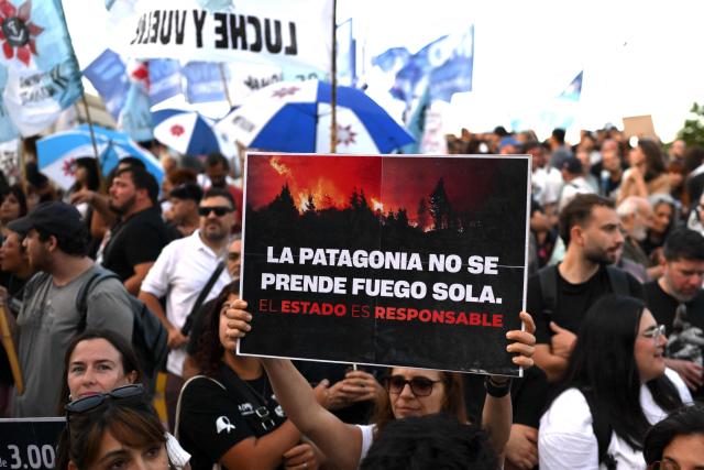 A woman shows a sign that reads "Patagonia does not burn on its own; the state is responsible" during a protest to demand more help to combat wildfires in Patagonia from Argentina's President Javier Milei government in Buenos Aires on January 30, 2026. Argentina's government on declared an emergency in Patagonia on January 29, 2026, where wildfires have ripped through vast tracts of forest since the start of the Southern Hemisphere summer. (Photo by Luis ROBAYO / AFP)