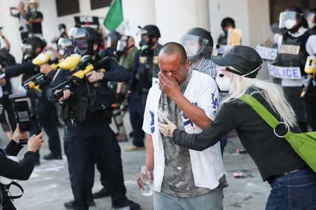 A man reacts after being gassed by police during a "National Shutdown" protest against U.S. Immigration and Customs Enforcement in Los Angeles on January 30, 2026. Donald Trump's border chief said January 29, 2026 that some federal agents could be withdrawn from Minneapolis, the northern US city that has become the flashpoint for the president's immigration crackdown. The Trump administration, facing a public backlash over the shooting deaths of two Americans by federal agents in Minneapolis, also eased immigration operations in the northeastern state of Maine. (Photo by Patrick T. Fallon / AFP)