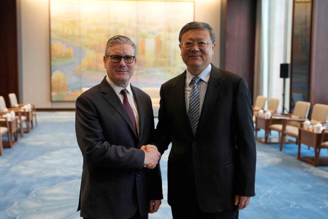 Britain's Prime Minister Keir Starmer (L) shakes hands with Shanghai Party Secretary Chen Jining (R) in Shanghai on January 31, 2026. (Photo by Kin Cheung / POOL / AFP)