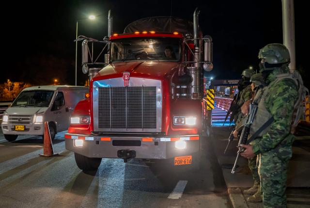 Ecuadorian soldiers guard the entrance of trucks across the border with Colombia before the new tariff measures imposed by the Ecuadorian government coming into effect in Tulcan, Ecuador on January 30, 2026. The countries imposed 30% tariffs on each other after Ecuador's President Daniel Noboa accused Colombia of not doing enough to combat drug trafficking along their shared border. The dispute escalated when Colombia suspended electricity sales to Ecuador, and Ecuador raised the tariff for transporting crude oil through its pipeline by 900%. (Photo by Reicarmyr CANIZARES / AFP)
