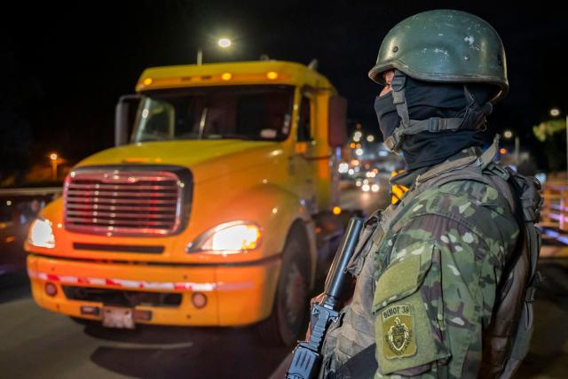 An Ecuadorian soldier guards the entrance of trucks across the border with Colombia before the new tariff measures imposed by the Ecuadorian government coming into effect in Tulcan, Ecuador on January 30, 2026. The countries imposed 30% tariffs on each other after Ecuador's President Daniel Noboa accused Colombia of not doing enough to combat drug trafficking along their shared border. The dispute escalated when Colombia suspended electricity sales to Ecuador, and Ecuador raised the tariff for transporting crude oil through its pipeline by 900%. (Photo by Reicarmyr CANIZARES / AFP)