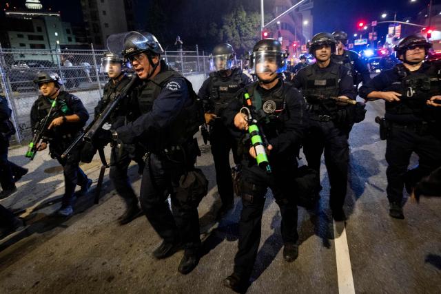 LAPD officers charge against protesters to remove them from the area around the Metropolitan Detention Center (MDC) during a "National Shutdown" protest against US Immigration and Customs Enforcement in Los Angeles on January 30, 2026. Donald Trump's border chief said January 29, 2026 that some federal agents could be withdrawn from Minneapolis, the northern US city that has become the flashpoint for the president's immigration crackdown. The Trump administration, facing a public backlash over the shooting deaths of two Americans by federal agents in Minneapolis, also eased immigration operations in the northeastern state of Maine. (Photo by ETIENNE LAURENT / AFP)