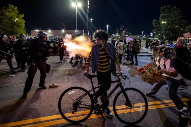 An LAPD officer fires a non-lethal munition while facing protesters during a "National Shutdown" protest against US Immigration and Customs Enforcement in Los Angeles on January 30, 2026. Donald Trump's border chief said January 29, 2026 that some federal agents could be withdrawn from Minneapolis, the northern US city that has become the flashpoint for the president's immigration crackdown. The Trump administration, facing a public backlash over the shooting deaths of two Americans by federal agents in Minneapolis, also eased immigration operations in the northeastern state of Maine. (Photo by ETIENNE LAURENT / AFP)