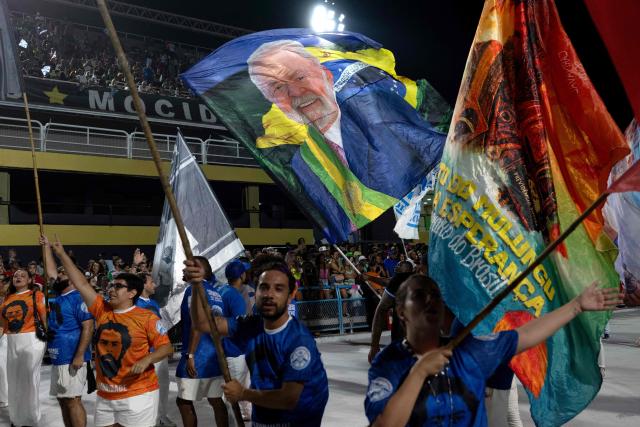 Revelers from the Academicos de Niteroi samba school wave flags depicting Brazil's President Luiz Inacio Lula da Silva during a technical rehearsal at the Sapucai sambadrome in Rio de Janeiro, Brazil on January 30, 2026. Academicos de Niteroi present an artistic proposal that pays tribute to Brazil's President Luiz Inacio Lula da Silva. (Photo by Pablo PORCIUNCULA / AFP)