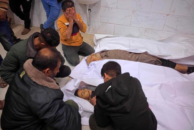 EDITORS NOTE: Graphic content / Mourners weep next to the bodies of Palestinians, who were reportedly killed by an Israeli air strike, in Khan Yunis, southern Gaza Strip on January 31, 2026. Israeli air strikes killed 11 people in the Gaza Strip on January 31, according to the territory's ministry of health, including people sheltering in a tent in the south. (Photo by Bashar Taleb / AFP)