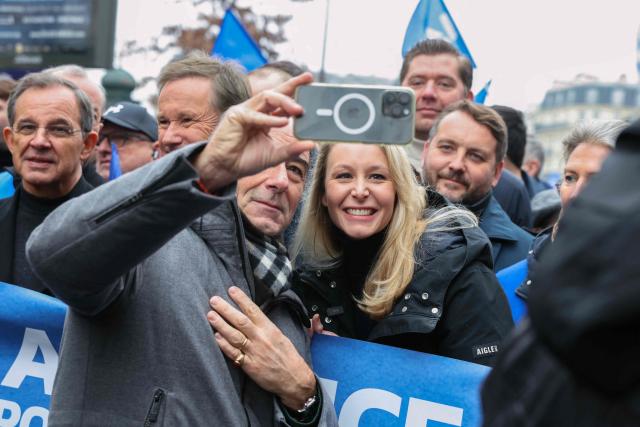 Right-wing European Conservatives and Reformists (ECR) MEP Marion Marechal (C) poses for a selfie photograph next to Rassemblement National's MP Thibaut Monnier (R) while taking part in a demonstration called by the union Alliance to denounce the lack of ressources in their corporation in Paris on January 31, 2026. (Photo by Alain JOCARD / AFP)