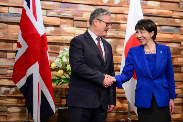 Japan's Prime Minister Sanae Takaichi (R) shakes hands with Britain's Prime Minister Keir Starmer ahead of a bilateral meeting at the Prime Minister's Office in Tokyo on January 31, 2026. (Photo by Yuichi YAMAZAKI / POOL / AFP)