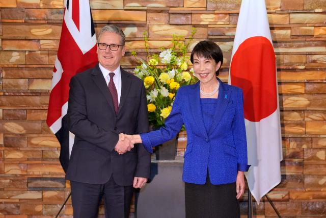 Britain's Prime Minister Keir Starmer (L) shakes hands with Japanese Prime Minister Sanae Takaichi at the prime minister's office in Tokyo on January 31, 2026. (Photo by Kin Cheung / POOL / AFP)
