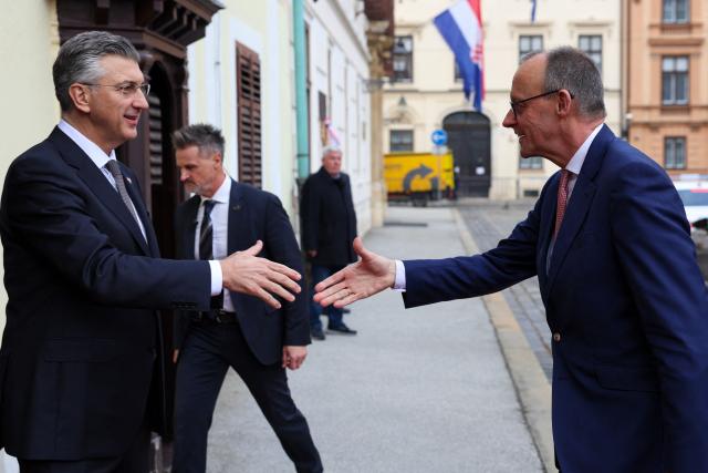 Croatia's Prime Minister Andrej Plenkovic (L) welcomes Germany's Chancellor Friedrich Merz (R) ahead of a meeting at the government building, in Zagreb, Croatia, on January 31, 2026. (Photo by MARKO PERKOV / AFP)