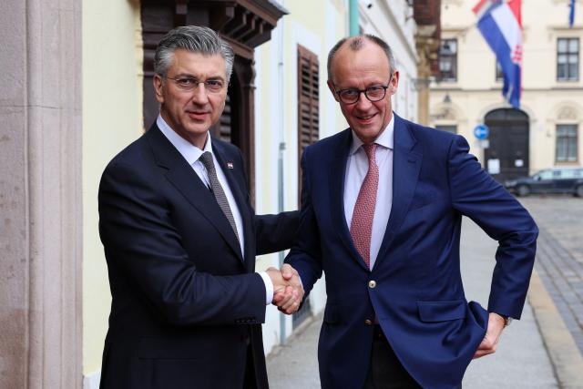 Croatia's Prime Minister Andrej Plenkovic (L) welcomes Germany's Chancellor Friedrich Merz (R) ahead of a meeting at the government building, in Zagreb, Croatia, on January 31, 2026. (Photo by MARKO PERKOV / AFP)
