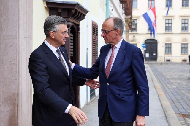 Croatia's Prime Minister Andrej Plenkovic (L) welcomes Germany's Chancellor Friedrich Merz (R) ahead of a meeting at the government building, in Zagreb, Croatia, on January 31, 2026. (Photo by MARKO PERKOV / AFP)