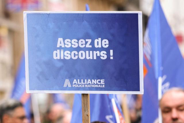 A protester holds a placard which reads as "Enough speeches" while taking part in a demonstration called by the union Alliance Police Nationale to denounce the lack of ressources in their corporation in Paris on January 31, 2026. (Photo by Alain JOCARD / AFP)