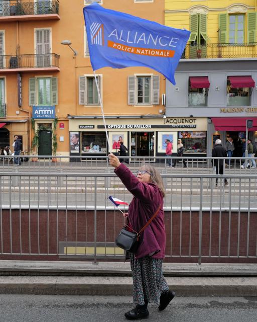A woman waves an Alliance union flag during a demonstration called by the Alliance Police Nationale union to denounce the lack of resources in their profession in Nice, south-eastern France, on January 31, 2026. (Photo by Valery HACHE / AFP)
