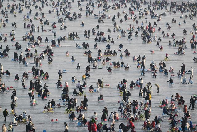 People chair-ski at the Summer Palace seasonal ice rink in Beijing on January 31, 2026. (Photo by Adek BERRY / AFP)