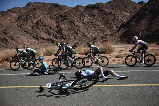 XDS Astana Team riders Colombian Sergio Higuita and Kazakh Yevgeniy Fedorov crash during the fifth and last stage of the AlUla Tour cycling race, 163.9km from AlUla Old Town to Skyviews of Harrat Uwayrid on January 31, 2026. (Photo by Anne-Christine POUJOULAT / AFP)