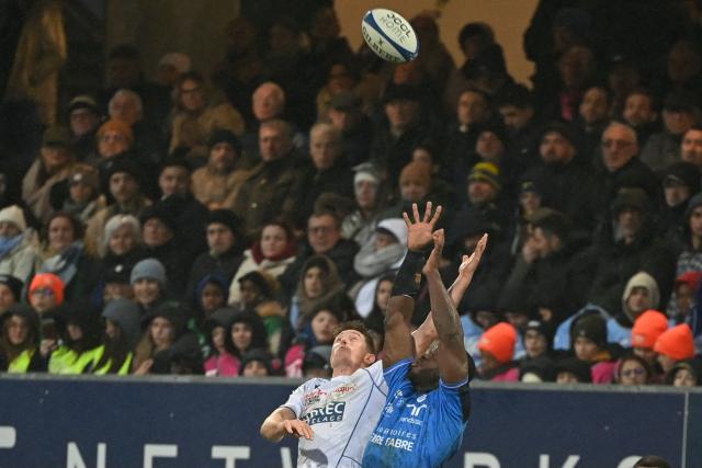 Clermont's Australian full-back Alex Newsome (L) fights for the ball with Castres' Cameroonian wing Christian Ambadiang during the French Top 14 rugby union match between Castres Olympique and ASM Clermont Auvergne at Stade Pierre Fabre in Castres, southern France on January 31, 2026. (Photo by Matthieu RONDEL / AFP)