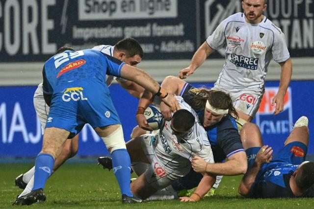 Clermont's French hooker Barnabe Massa (C) is tackled during the French Top 14 rugby union match between Castres Olympique and ASM Clermont Auvergne at Stade Pierre Fabre in Castres, southern France on January 31, 2026. (Photo by Matthieu RONDEL / AFP)