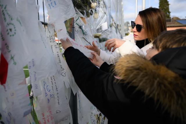 Benjamin Maé Brodard (R), brother of victim Arthur who died in the fire hangs a note as he takes part to a silent march organized in memory of some of the victims of the Crans Montana deadly New Year's Eve fire, in Lutry, near Lausanne, on January 31, 2026. The fire on January 1 at the bar "Le Constellation" left 40 people dead -- including nine French and six Italian nationals -- and injured 116 others, most of them teenagers. (Photo by Harold CUNNINGHAM / AFP)