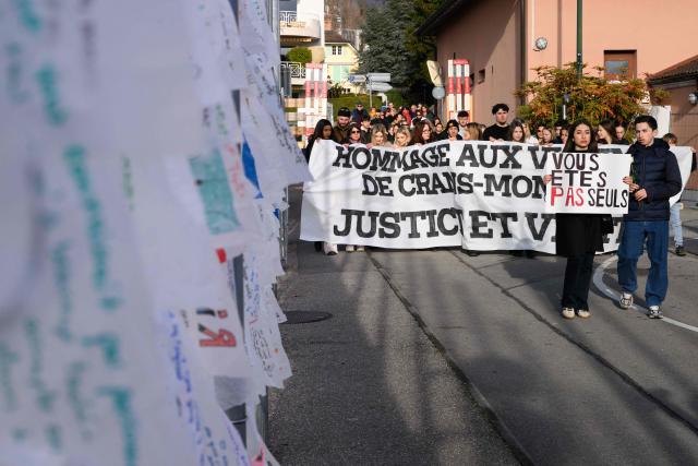 Attendees with a banner reading "tribute to the victims of Crans Montana, justice and truth" take part in a silent march organized in memory of some of the victims of the Crans Montana deadly New Year's Eve fire, in Lutry, near Lausanne, on January 31, 2026. The fire on January 1 at the bar "Le Constellation" left 40 people dead -- including nine French and six Italian nationals -- and injured 116 others, most of them teenagers. (Photo by Harold CUNNINGHAM / AFP)