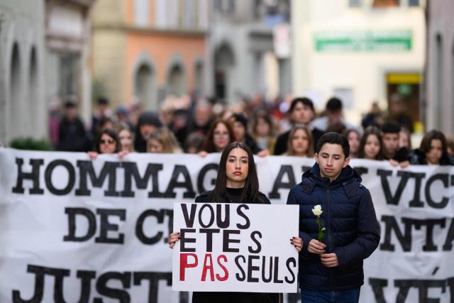 An attendee with a placard reading "you are not alone" takes part in a silent march organized in memory of some of the victims of the Crans Montana deadly New Year's Eve fire, in Lutry, near Lausanne, on January 31, 2026. The fire on January 1 at the bar "Le Constellation" left 40 people dead -- including nine French and six Italian nationals -- and injured 116 others, most of them teenagers. (Photo by Harold CUNNINGHAM / AFP)