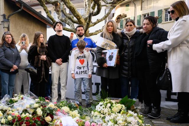 Benjamin Maé Brodard (bottom C), brother of victim Arthur who died in the fire shows a message  reading "Arthur we love you" as he takes part with his father in a silent march organized in memory of some of the victims of the Crans Montana deadly New Year's Eve fire, in Lutry, near Lausanne, on January 31, 2026. The fire on January 1 at the bar "Le Constellation" left 40 people dead -- including nine French and six Italian nationals -- and injured 116 others, most of them teenagers. (Photo by Harold CUNNINGHAM / AFP)
