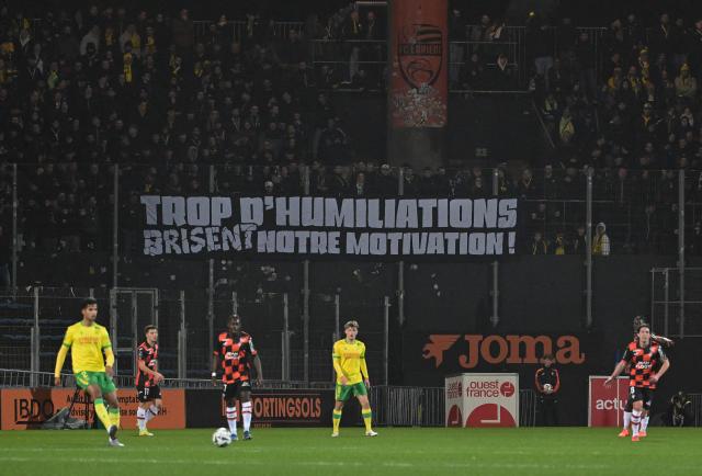 Supporters display a banner reading "too much humiliation break our motivation" during the French L1 football match between FC Lorient and FC Nantes at the Stade du Moustoir in Lorient, western France, on January 31, 2026. (Photo by Damien Meyer / AFP)