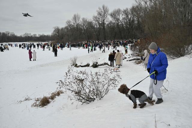 People attend an outdoor party on a side of the frozen Dnipro River in a residential neighbourhood of Kyiv, on January 31, 2026, to lift spirits during mass power outages amid the Russian invasion of Ukraine. (Photo by Genya SAVILOV / AFP)