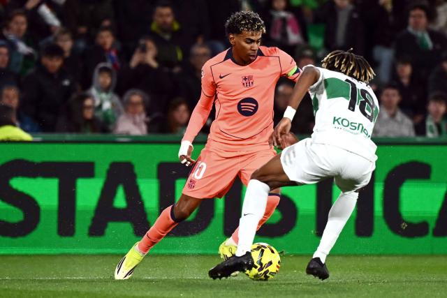 Barcelona's Spanish forward #10 Lamine Yamal and Elche's Spanish defender #18 John Donald fight for the ball during the Spanish league football match between Elche CF and FC Barcelona at thge Martinez Valero stadium in Elche on January 31, 2026. (Photo by JOSE JORDAN / AFP)