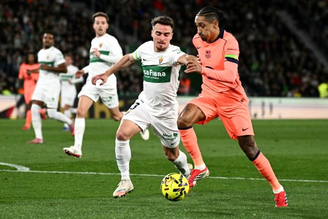 Elche's Spanish defender #03 Adria Pedrosa fights for the ball with Barcelona's Brazilian forward #11 Raphinha (R) during the Spanish league football match between Elche CF and FC Barcelona at thge Martinez Valero stadium in Elche on January 31, 2026. (Photo by JOSE JORDAN / AFP)