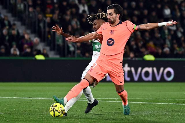 Elche's Spanish defender #18 John Donald (L) and Barcelona's Spanish forward #07 Ferran Torres fight for the ball during the Spanish league football match between Elche CF and FC Barcelona at thge Martinez Valero stadium in Elche on January 31, 2026. (Photo by JOSE JORDAN / AFP)